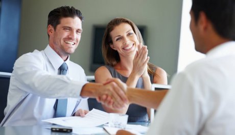 Two young entrepreneurs shaking hands after receiving a tender for their business venture